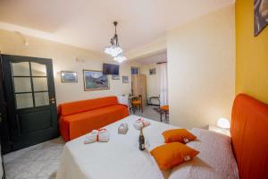 a bedroom with a bed and a orange couch at B&b "Terra du suli" in Cefalù