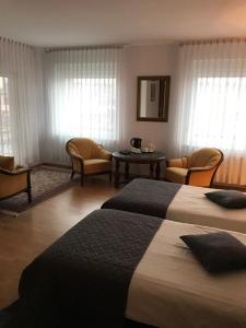 a hotel room with two beds and a table and chairs at Monte Christo in Miastko