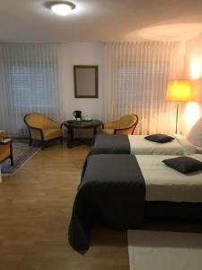 um quarto de hotel com duas camas e uma mesa e cadeiras em Monte Christo em Miastko