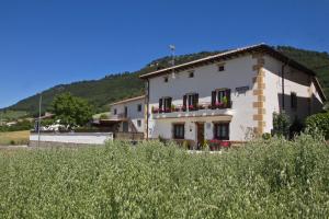 a large white building with flowers on the windows at Casa Rural Lazkano en Sierra de Urbasa in San Martín