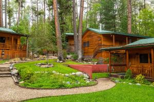 a log cabin in the woods with a yard at Riverside Cottage #26 in Ruidoso