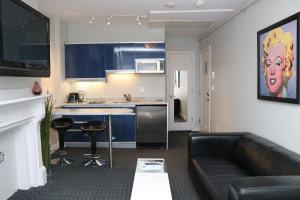 a living room with a couch and a kitchen at Stylish Studio on Newbury Street, #10 in Boston