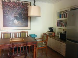 a kitchen with a wooden table with chairs and a refrigerator at El Mar House Parga in Parga