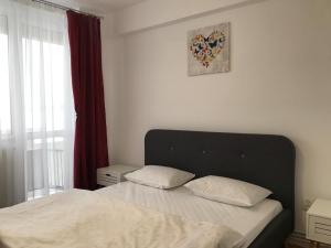 a bedroom with a bed and a window with avertisement at Central View Apartment in Timişoara