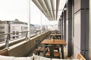 una fila de mesas y sillas en un balcón en Hotel Work Life Residence am Bahnhof, en Winterthur