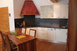 una cucina con tavolo in legno e soffitto rosso di Haus Bergheim a Unken