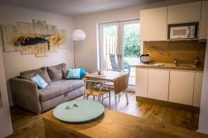 a kitchen and a living room with a couch and a table at WeststrandPur in Norderney