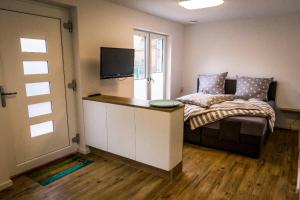 a bedroom with a bed with a desk and a television at WeststrandPur in Norderney