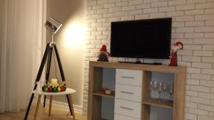 a flat screen tv sitting on top of a entertainment center at PANORAMA KOSZALIN in Koszalin