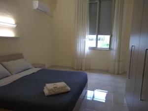 ein Schlafzimmer mit einem blauen Bett und einem Fenster in der Unterkunft Appartamento Via Vulcano in Trapani