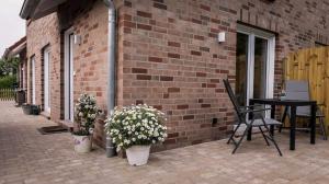 a brick building with a table and chairs and flowers at WeststrandPur in Norderney +7 photos