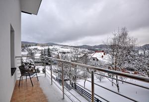 a balcony with a view of a snow covered yard at Willa MAJA in Krynica Zdrój +12 photos