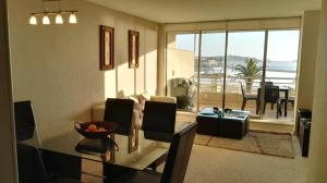 Sala de estar con mesa de comedor y vistas al océano en Departamento San Alfonso, en Algarrobo