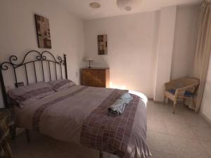 ein Schlafzimmer mit einem großen Bett und einem Stuhl in der Unterkunft Casa Ghalia in Cenes de la Vega