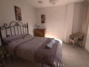 セネス・デ・ラ・ベガにあるCasa Ghaliaのベッドルーム(大型ベッド1台、椅子付)