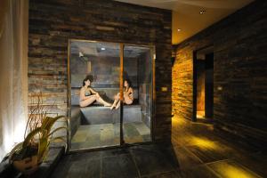 a room with two women sitting in a bath tub at Hotel Life in Rimini