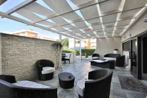 a patio with couches and chairs under a roof at Hotel Life in Rimini