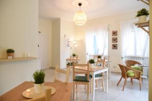 a dining room and living room with a table and chairs at Villa Le Garden in Nettuno