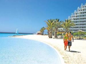 a man and a woman standing on a beach at SAN ALFONSO DEL MAR-PRECIOSO DEPARTAMENTO Y VISTA in Algarrobo