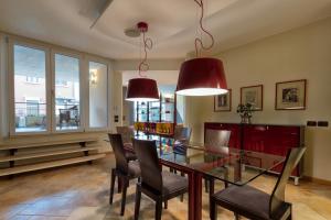uma sala de jantar com uma mesa de vidro e cadeiras em Residenza Montebello em Verona