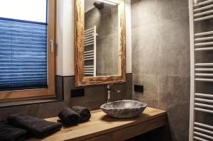 a bathroom with a sink and a mirror at Zeitfrei Chalet Apartments in Fieberbrunn +86 photos
