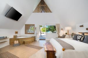 a bedroom with a bed and a tv and a desk at Punta Rucia Lodge Hotel Boutique & Spa in Punta Rucia
