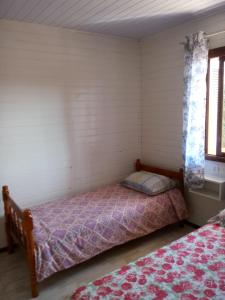 een kleine slaapkamer met een bed en een raam bij Residencial Gurtler 209 in Gramado
