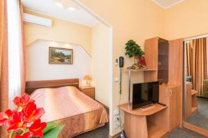 a hotel room with a bed and a television at Profsoyuznaya Hotel in Nizhny Novgorod