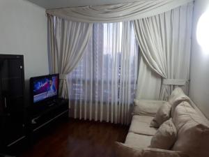 a living room with a couch and a television at Campanario 104 con factura in Iquique