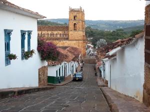 a street in a town with a church at Casa Doña Rosaura Barichara ALQUILER Entero in Barichara