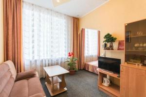 a living room with a couch and a bed and a television at Profsoyuznaya Hotel in Nizhny Novgorod