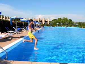 a young man running into a swimming pool at Cosmopolitan Golf & Beach Resort in Tirrenia