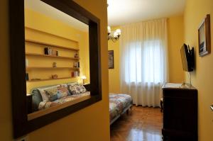 una camera da letto con un letto e uno specchio in una stanza di Casa Max a Napoli