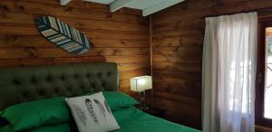 1 dormitorio con cama verde y pared de madera en LA MATERA Suites, en Costa del Este