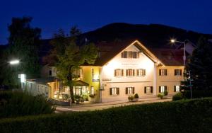 ein großes weißes Gebäude mit Lichtern in der Nacht in der Unterkunft Gasthof Engelhof in Gmunden