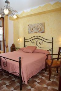 um quarto com uma cama com lençóis cor-de-rosa e uma cadeira em Rabbit em Agerola