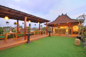 uma casa com um deque com um relvado verde em Meranggi Home Stay em Ubud