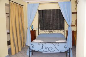 a bedroom with a canopy bed with a window at Casa Matarazzo in Lipari