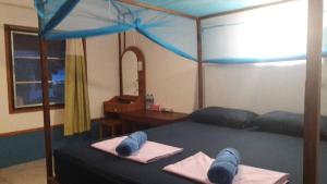 a bedroom with a bed with a blue canopy at Koh Ngai Seafood in Ko Ngai