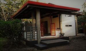 un pequeño edificio con techo rojo y escalera en SomeWhere Else Boutique Resort en Mambajao