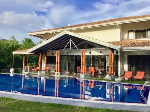 a house with a swimming pool in front of it at Tropical Dream Villa in Unawatuna