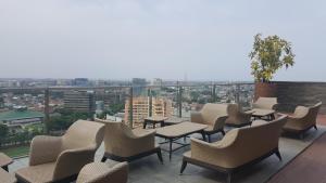 a group of chairs and tables on a balcony at Warhol Apartement Lt 15 Jl. Ahmad Yani Simpang 5 Semarang in Semarang
