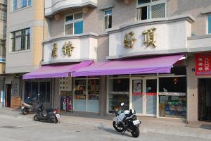 南竿依金那海景民宿的两辆摩托车停在一座紫色遮篷建筑前面