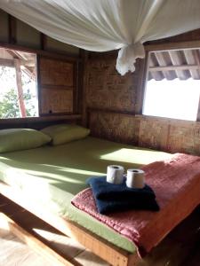 Una cama en una cabaña con dos toallas. en Nice View Bungalow en Koh Chang