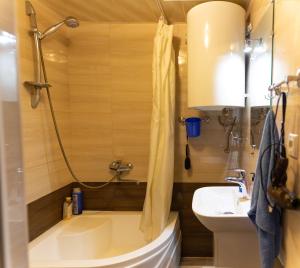 a small bathroom with a tub and a sink at Guest House Hello in Tbilisi City