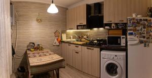 a kitchen with a stove, sink, microwave and refrigerator at Guest House Hello in Tbilisi City