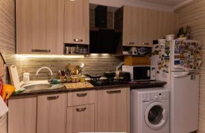 a kitchen with a stove, refrigerator, sink and dishwasher at Guest House Hello in Tbilisi City