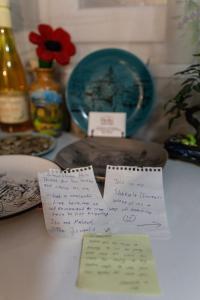 a table with some notes on a table with a plate w obiekcie Guest House Hello w mieście Tbilisi City