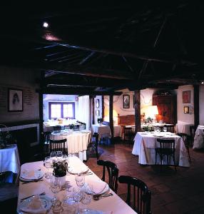 ein Esszimmer mit Tischen und Stühlen sowie weißer Tischwäsche in der Unterkunft Hotel El Rancho in Segovia