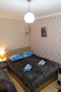 a bedroom with a bed and a lamp at Guest House Hello in Tbilisi City